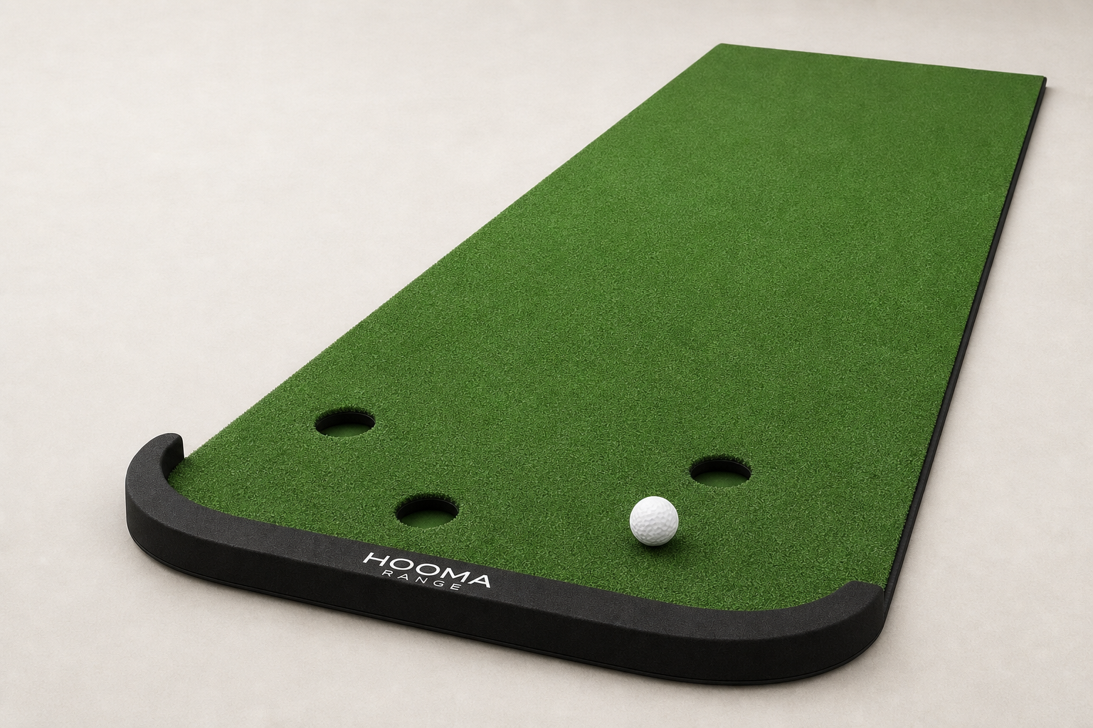 Close-up of the HOOMA RANGE three-hole putting mat and raised black end bumper